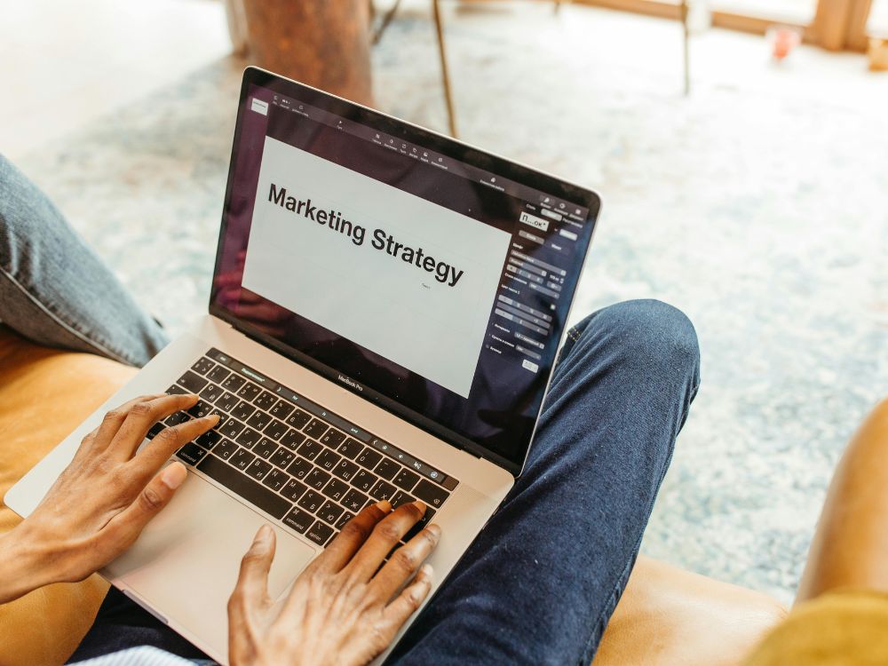 Pessoa trabalhando no notebook com estratégias para ganhar dinheiro com marketing digital